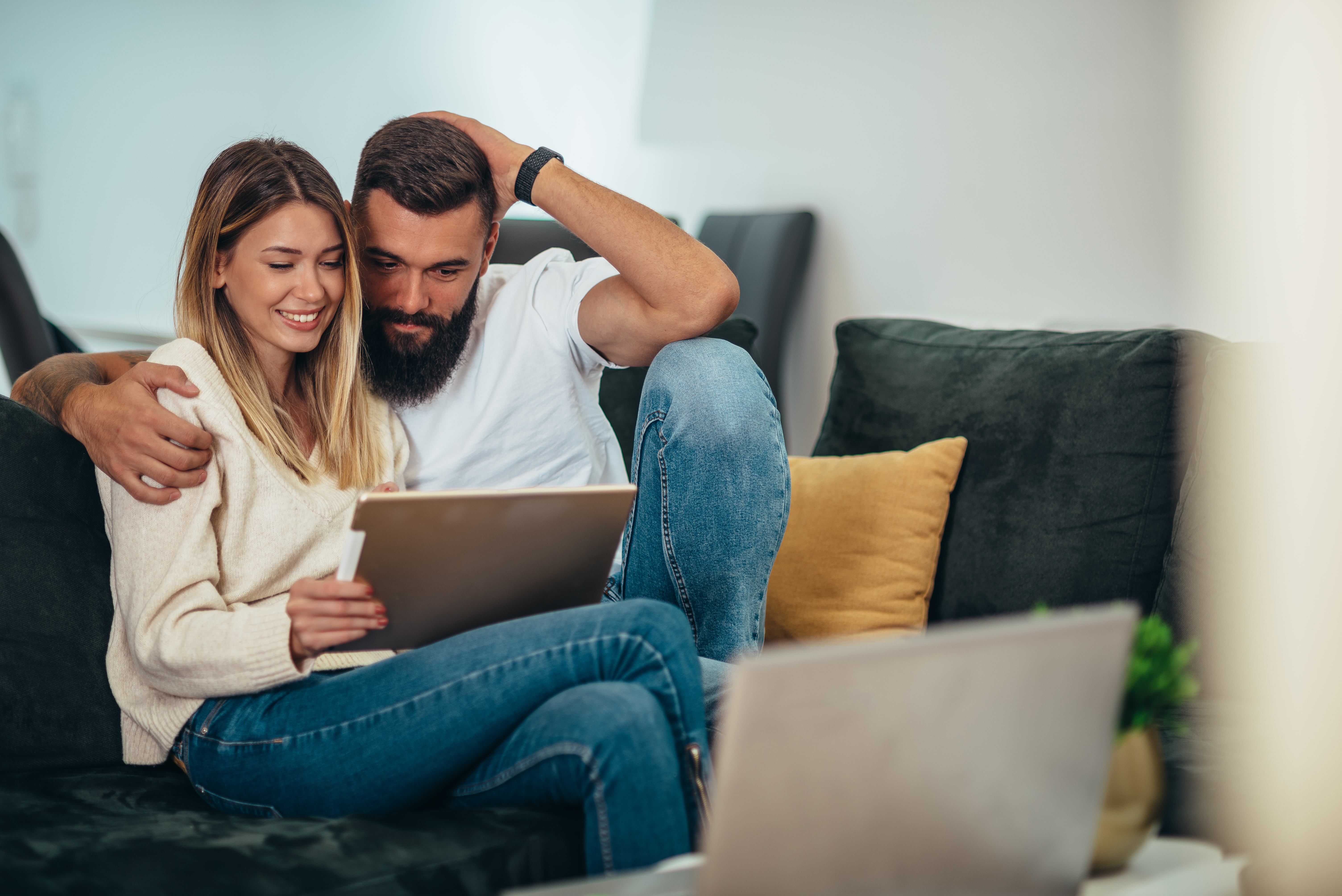 Man and woman on couch looking at tablet. Man and woman on couch looking at tablet.