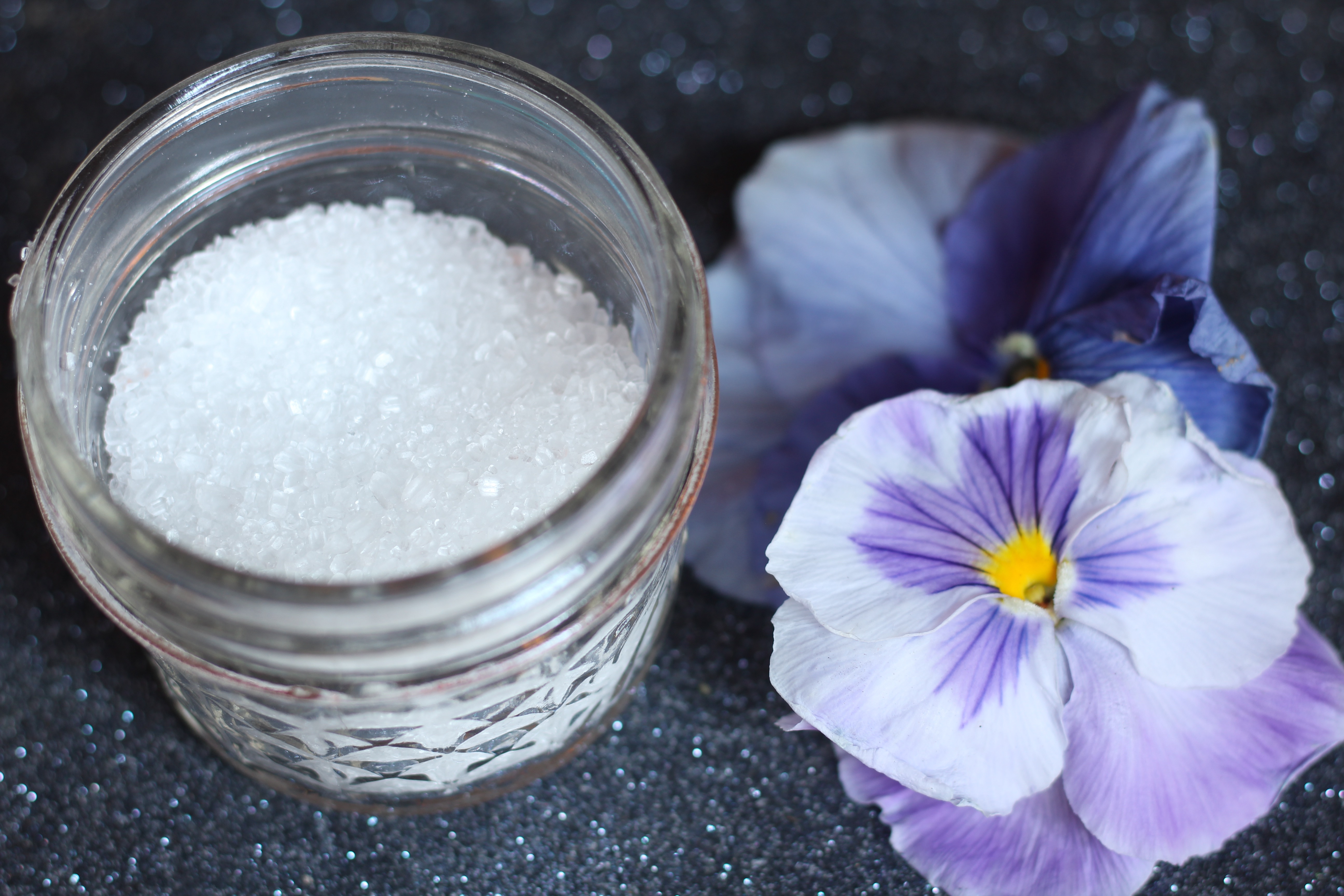Jar of epsom salt and purple flower Jar of epsom salt and purple flower