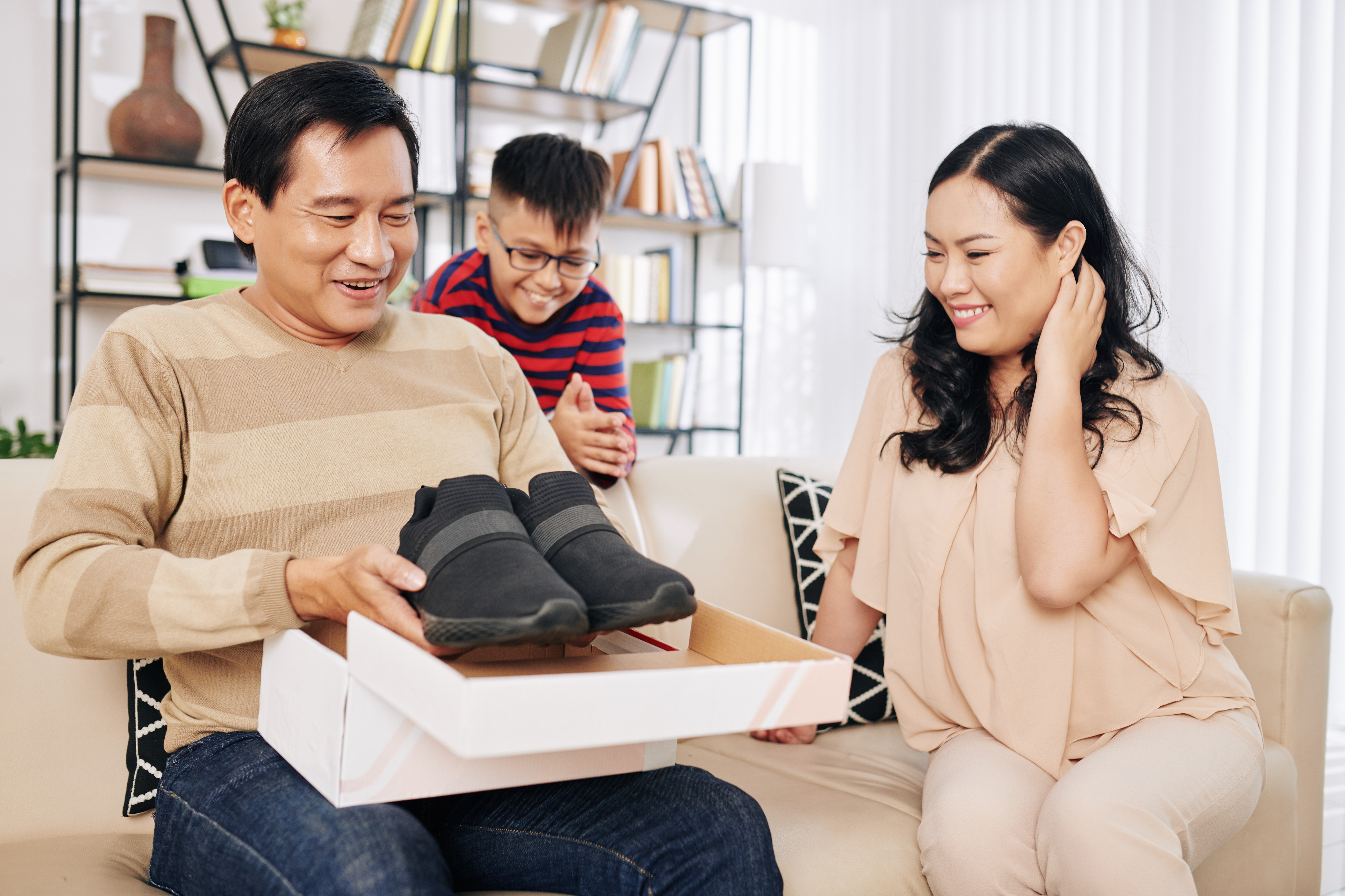 Man receiving running shoes from family. Man receiving running shoes from family.