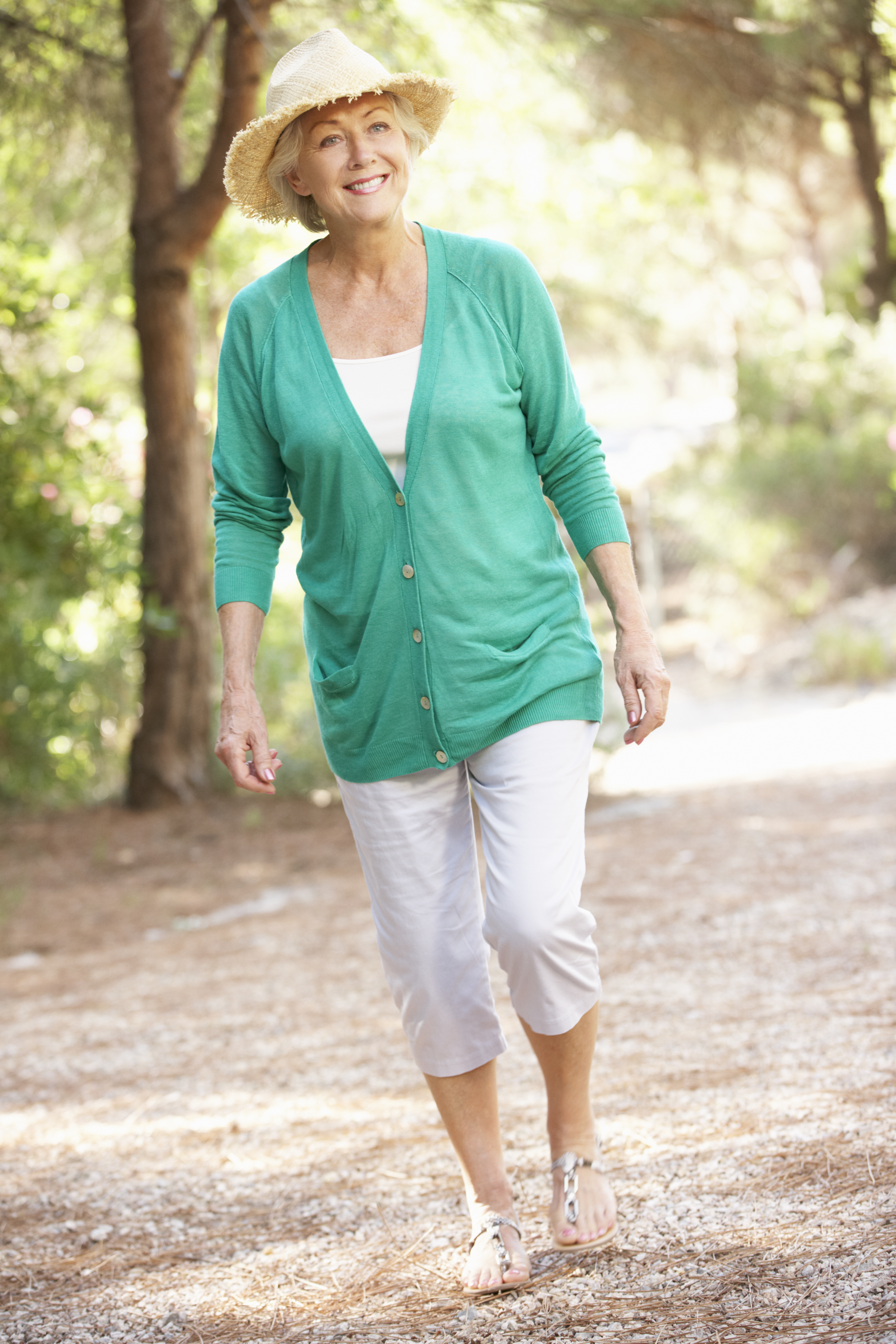 Smiling woman walking through forest on sunny day. Smiling woman walking through forest on sunny day.
