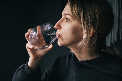 Woman taking pills with water Woman taking pills with water