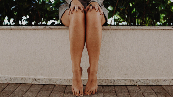 Close Up of Woman's Legs. Woman Sitting On Outside Ledge Close Up of Woman's Legs. Woman Sitting On Outside Ledge